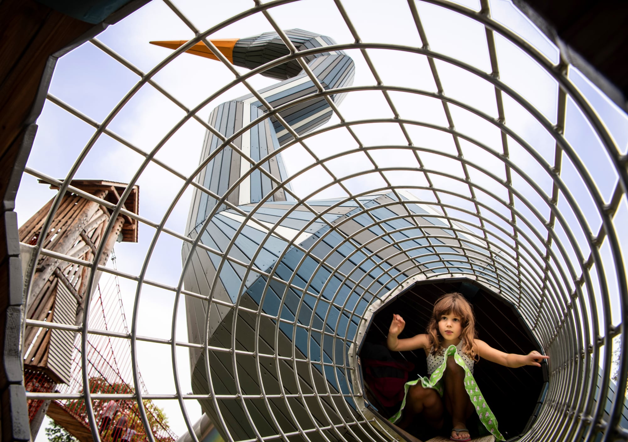 A young, female student walks through a larger than life animal sculpture at Gathering Place.